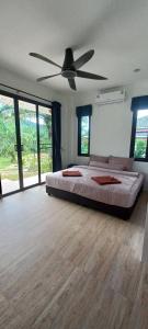a bedroom with a bed and a ceiling fan at Koh Lanta MaiKaew Villa in Ban Ru Yai