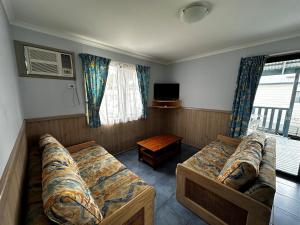 Habitación con 2 camas, sofá y TV. en Big4 Ulladulla Beachside Holiday Park, en Ulladulla