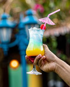 a hand holding a drink with an umbrella at CASA IMPERIAL HOTEL POUSADA in São Luís