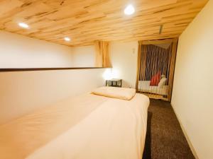 a bedroom with a bed in a room with a window at USJ 2 stops, Umeda&Dotonbori 8mins, Ninja Style SV1 in Osaka