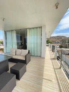 ein Wohnzimmer mit einem Sofa und einem Tisch auf dem Balkon in der Unterkunft Hotel Pinos del Mar in Zorritos