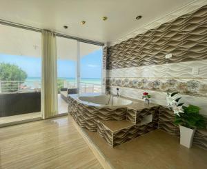 La salle de bains est pourvue d'une baignoire et offre une vue sur l'océan. dans l'établissement Hotel Pinos del Mar, à Zorritos