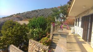 a house with stairs with a mountain in the background at Apartment and Rooms Busa 3 in Senj