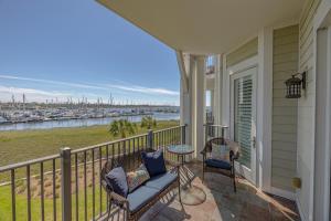 a porch with two chairs and a table with a view of a harbor at Marina Retreat in Saint Simons Island
