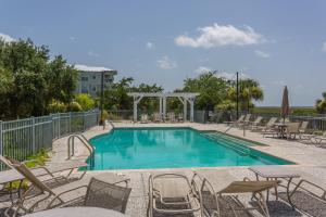 a swimming pool with chairs and a table at Marina Retreat in Saint Simons Island