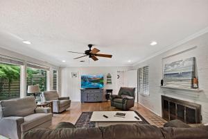 a living room with a ceiling fan and a fireplace at The Pink House in Saint Simons Island