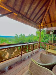 una terraza de madera con sillas y una mesa. en Rajaklana Resort and Spa en Bantul