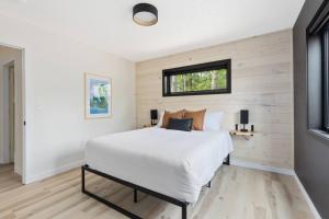 a bedroom with a white bed and a window at Cuyuna Adventure Cabin: Solo Stove - On Bike Trail in Crosby