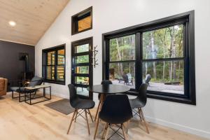 a dining room with a table and chairs and windows at Cuyuna Adventure Cabin: Solo Stove - On Bike Trail in Crosby +27 photos