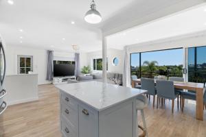 a kitchen and living room with a table and a dining room at Beach Vibe at Terrigal in Terrigal