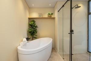 La salle de bains est pourvue de toilettes et d'une douche en verre. dans l'établissement Olive Living Suites by HOUSY HOST, à Envigado