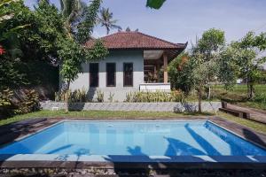 a swimming pool in front of a house at Mejan Home Stay in Balian