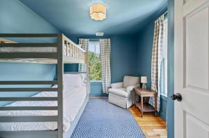 a childs room with a bunk bed and a chair at The Blueberry House - Spacious, Family & Pet-Friendly Retreat near Sebago Lake in North Sebago