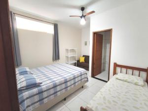 1 dormitorio con 1 cama y ventilador de techo en Apartamento em Ilha bela, en Ilhabela