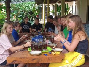 eine Gruppe von Menschen, die an einem Tisch sitzen in der Unterkunft FAREL HOMESTAY KAWAHIJEN in Banyuwangi