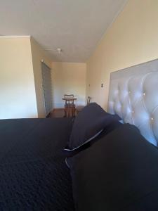 een slaapkamer met een groot bed en een tafel bij Casa de Huéspedes en Paine in Paine