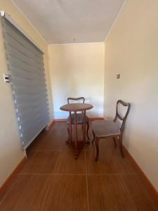 Zimmer mit einem Tisch, einem Stuhl und einem Fenster in der Unterkunft Casa de Huéspedes en Paine in Paine