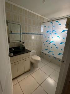 ein Badezimmer mit einem WC und einer Dusche mit blauen Vögeln an der Wand in der Unterkunft Casa de Huéspedes en Paine in Paine