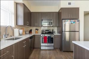 a kitchen with stainless steel appliances and wooden cabinets at Lux Playa Vista 2 BDRM Condo in Los Angeles