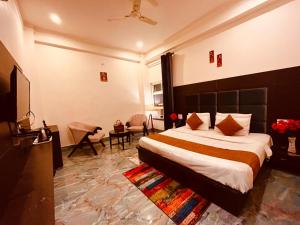une chambre avec un grand lit et un salon dans l'établissement Hotel NDBL Near Hari Ki Pauri Haridwar, à Haridwar