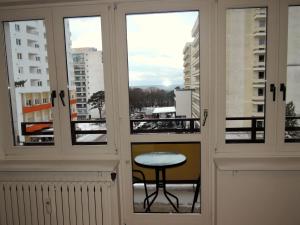 a room with windows with a table and a balcony at Beautiful apartment with sea views in Miedzyzdroje in Międzyzdroje