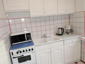a white kitchen with a stove and a sink at Beautiful apartment with sea views in Miedzyzdroje in Międzyzdroje