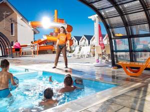 Eine Frau steht in einem Pool mit Kindern im Wasser in der Unterkunft Holiday Home in Sarbinowo near Baltic Beach in Sarbinowo + 23 Fotos