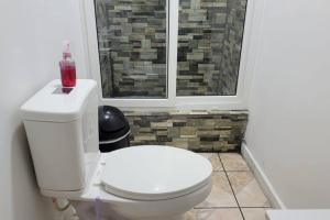 a bathroom with a white toilet with a window at 1 Bedroom Apartment in center of town. in Utila
