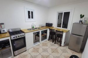 uma cozinha com um fogão, um lavatório e um frigorífico em 1 Bedroom Apartment in center of town. em Útila