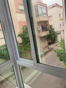 una ventana abierta con vistas a un edificio en Appartement chez Elmehdi, en Fez