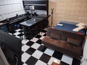 cocina con sofá y suelo de tablero de ajedrez en Pousada Interpraias, en Balneário Camboriú