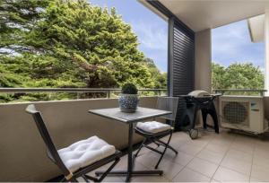 a patio with a table and chairs on a balcony at Domain 27 Apartment - Barton in Kingston 