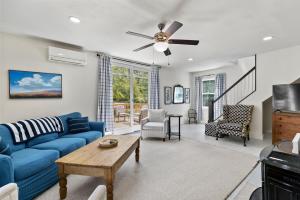 a living room with a blue couch and a ceiling fan at The Blueberry House - Spacious, Family & Pet-Friendly Retreat near Sebago Lake in North Sebago