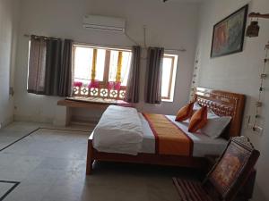a bedroom with a bed and two windows at SHIVA HAVELI in Jaisalmer