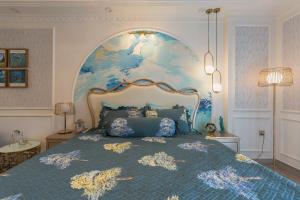 a bedroom with a large bed with a blue bedspread at Broccoli's House (Súp Lơ House) in Da Lat