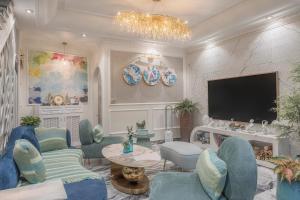 a living room with blue furniture and a flat screen tv at Broccoli's House (Súp Lơ House) in Da Lat