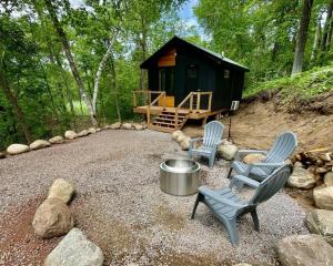 a small cabin with two chairs and a table and a barrel at *Tiny House Luxury Getaway: Solo Stove, Adventure* in Ironton