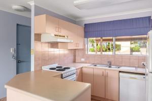 uma cozinha com um fogão branco e um lavatório em Rainbow Sands Resort em Rainbow Beach