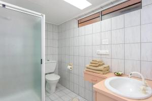 a bathroom with a sink and a toilet and a shower at Rainbow Sands Resort in Rainbow Beach