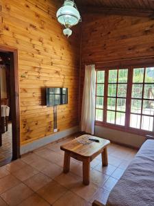 a living room with wooden walls and a table at Alerce Bariloche in San Carlos de Bariloche