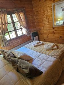 a bedroom with two beds in a log cabin at Alerce Bariloche in San Carlos de Bariloche