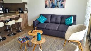sala de estar con sofá, mesa y sillas en Bello departamento en Bahia Inglesa, en Bahía Inglesa