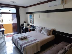 1 dormitorio con cama y sofá en Pousada Interpraias, en Balneário Camboriú