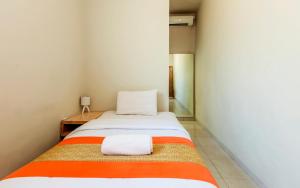 a bedroom with a bed with two pillows on it at Cityzen Renon Hotel in Denpasar