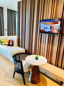 a living room with a table and a couch and a tv at Dor-Shada Resort By The Sea in Na Jomtien
