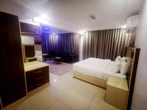 a hotel room with a large bed and a desk at Diamond Star Hotel فندق النجمة الماسية in Seeb