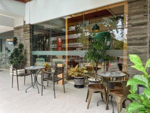 a restaurant with tables and chairs in front of a building at Kuta Majesty Hotel in Legian