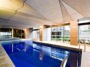 une grande piscine avec de l'eau bleue dans un immeuble dans l'établissement Marvellous 2-Bed High-Rise: Amazing Views, Free Parking, à Melbourne