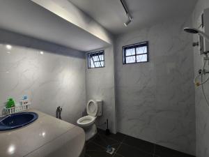 La salle de bains est pourvue d'un lavabo, de toilettes et de 2 fenêtres. dans l'établissement NEW! Petaling Jaya Landed Home next to Paradigm Mall, LDP, 5 Bedroom for up to 18Pax, à Petaling Jaya