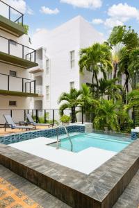 um edifício de apartamentos com piscina e palmeiras em The Balfour Hotel em Miami Beach